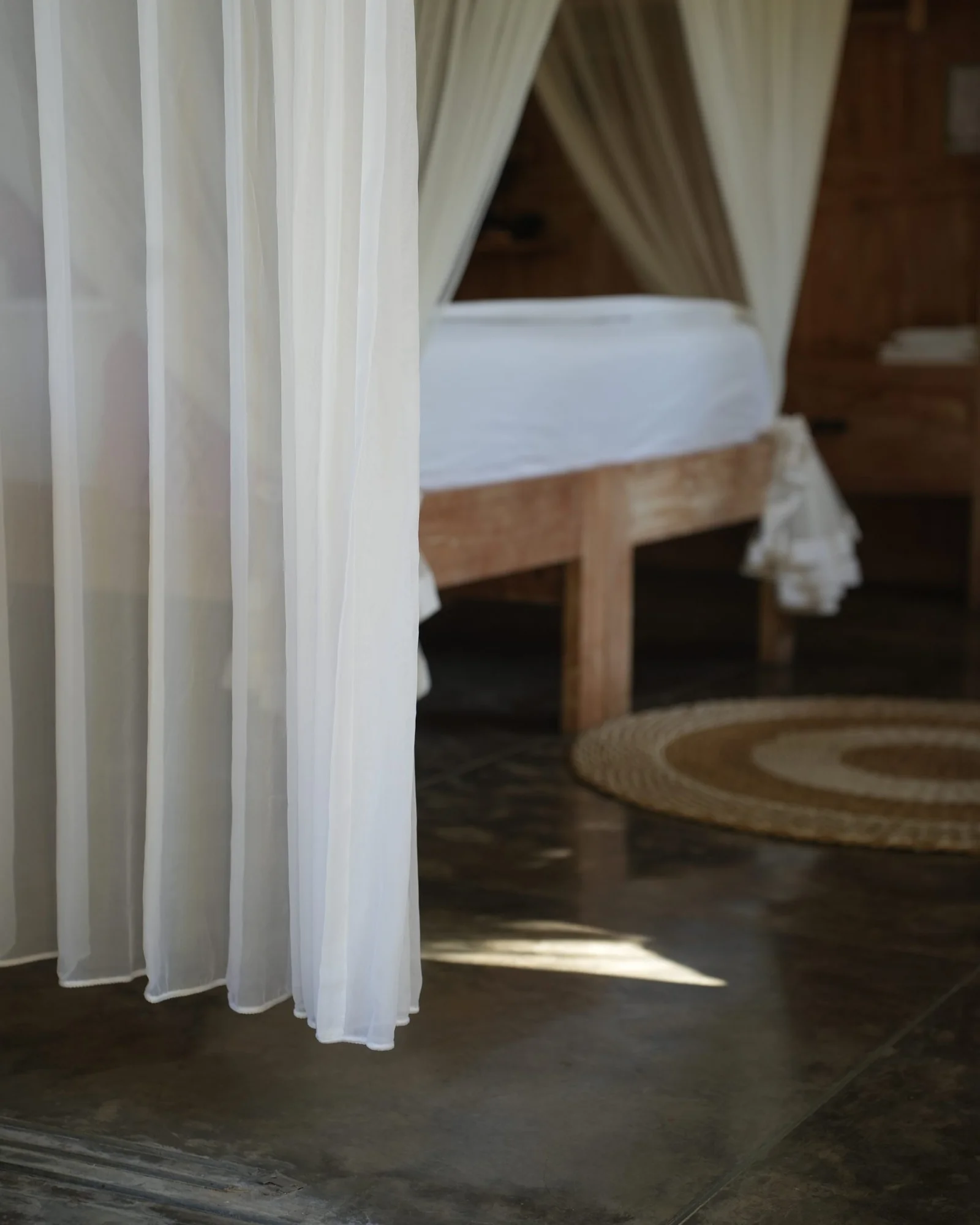 Sheer curtains drawn around a canopy bed