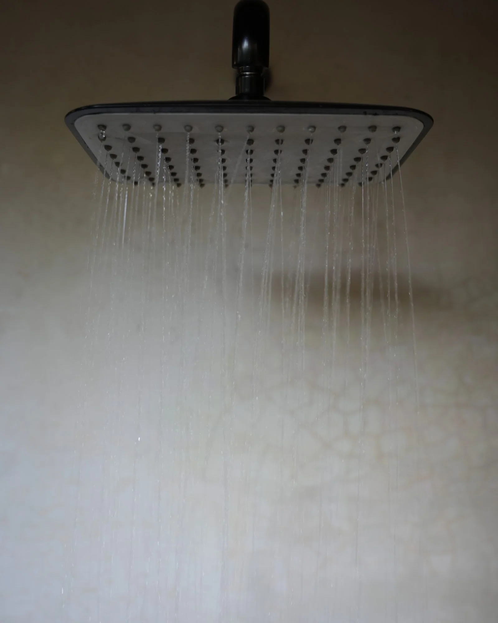 Water falling from a rain shower head in an outdoor bathroom