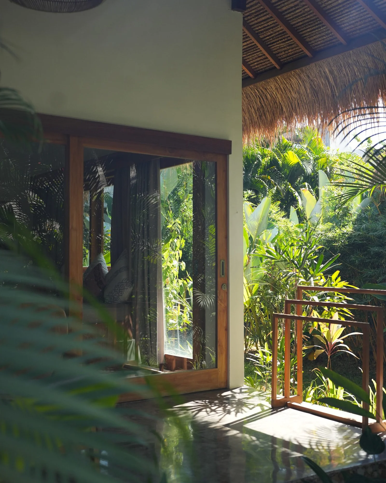 Villa doors open onto a balcony and tropical garden