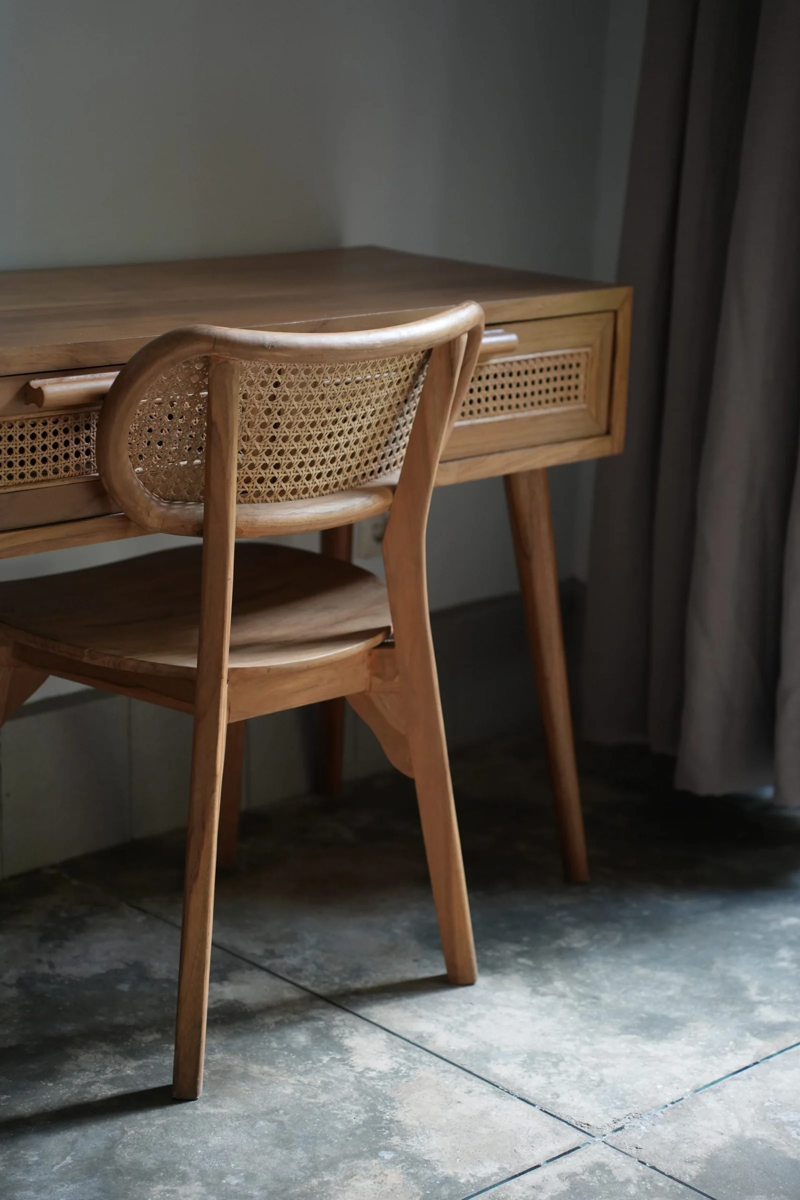 Timber writing desk and rattan chair in a villa at Mana Eco Retreat