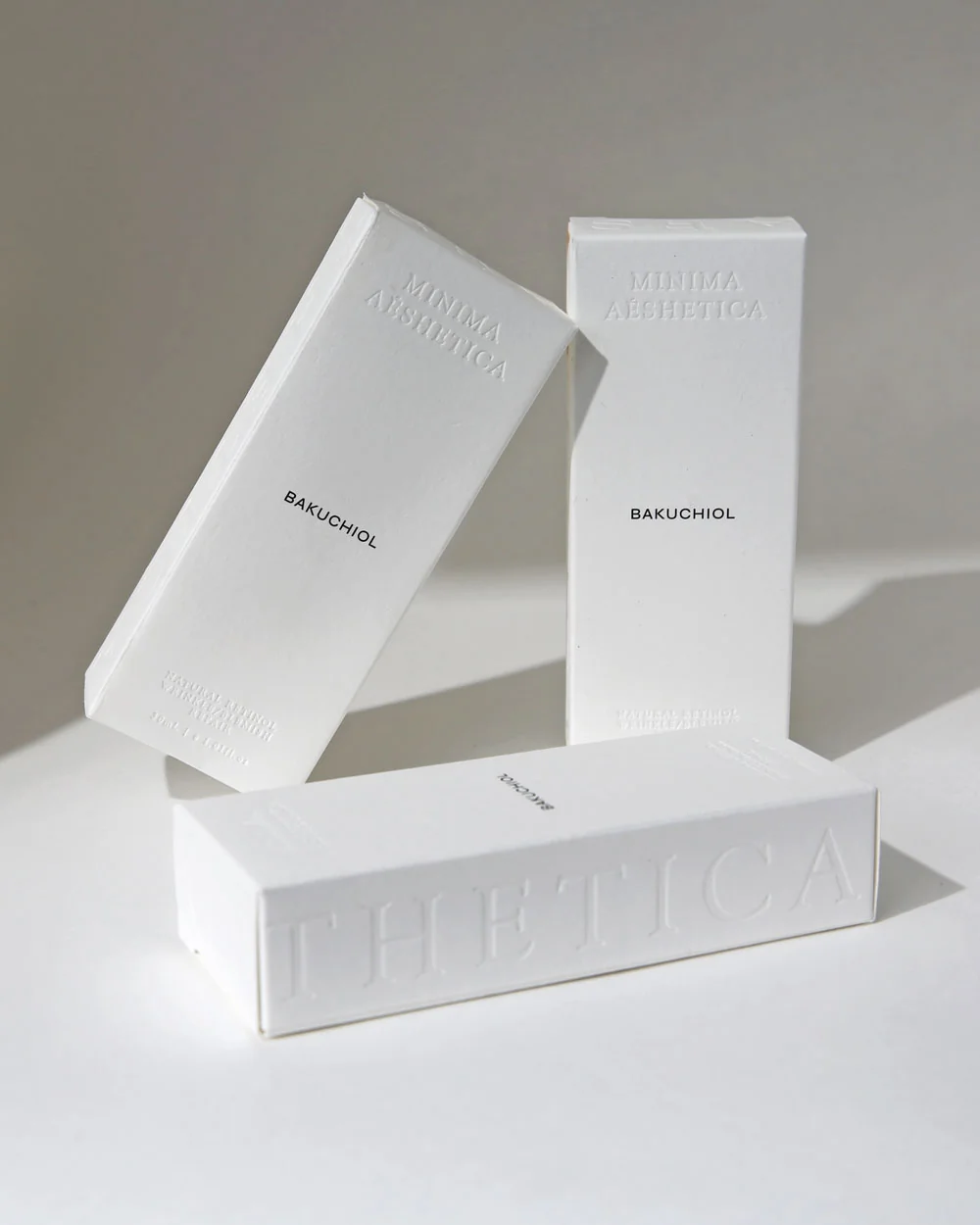 Minima Aesthetica packaging: three embossed white boxes