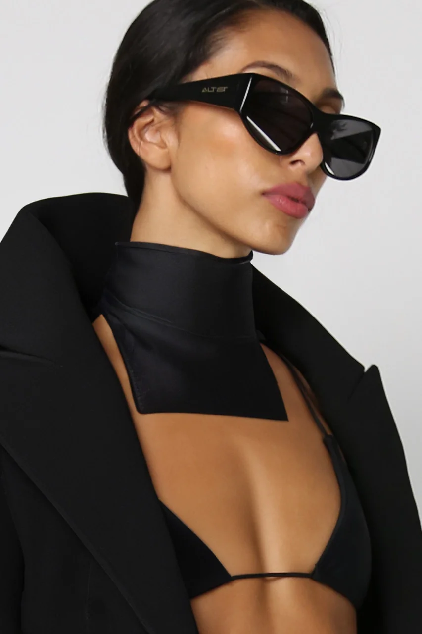 Model in black cat-eye sunglasses and a black coat for St.St